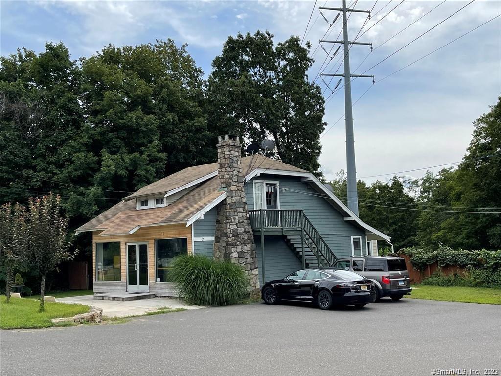 261 Danbury Road Wilton, CT 06897 - Photo 1 of 1 a car parked in front of a house