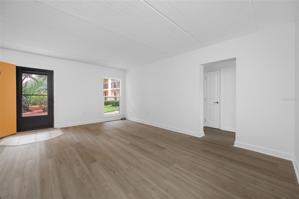 8911 Blind Pass Road, Unit 114 St. Pete Beach, FL 33706 - Photo 15 of 43 an empty room with wooden floor and windows