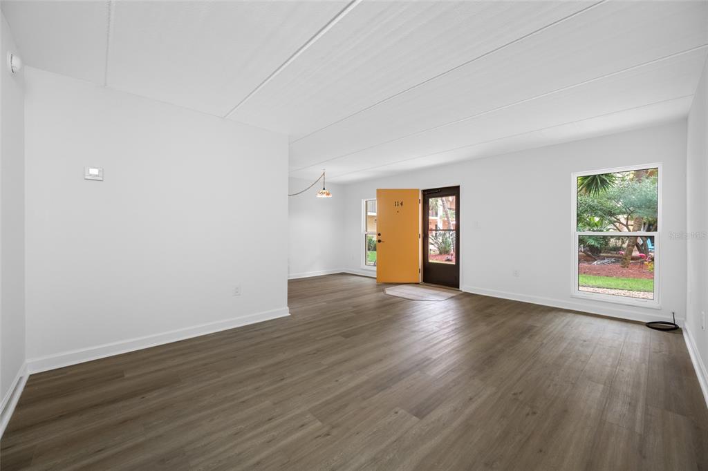 8911 Blind Pass Road, Unit 114 St. Pete Beach, FL 33706 - Photo 16 of 43 a view of an empty room with wooden floor and window