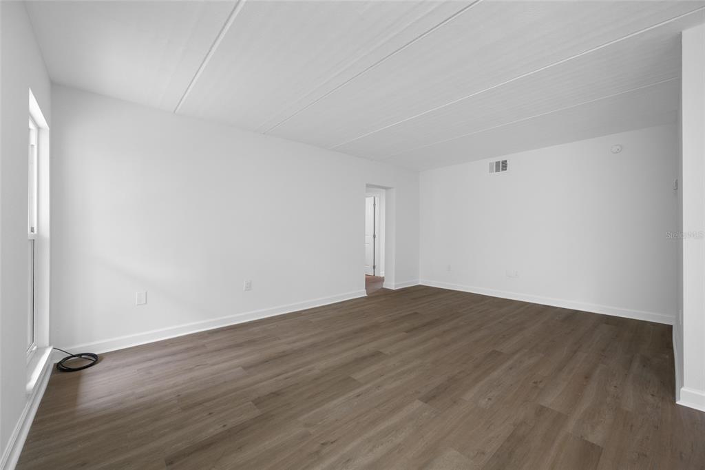 8911 Blind Pass Road, Unit 114 St. Pete Beach, FL 33706 - Photo 18 of 43 a view of an empty room with wooden floor