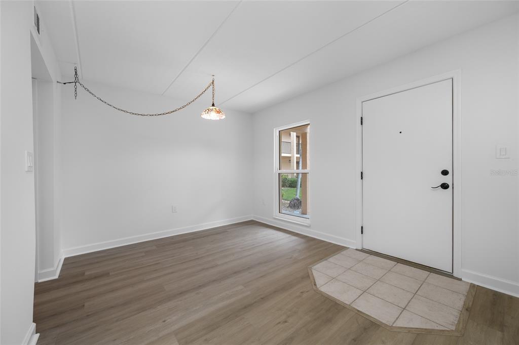 8911 Blind Pass Road, Unit 114 St. Pete Beach, FL 33706 - Photo 19 of 43 a view of an empty room with wooden floor and windows