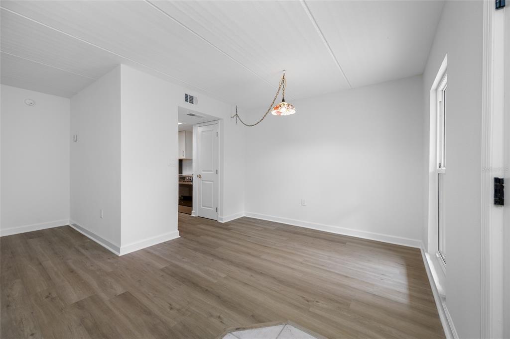 8911 Blind Pass Road, Unit 114 St. Pete Beach, FL 33706 - Photo 20 of 43 a view of an empty room with wooden floor and a window