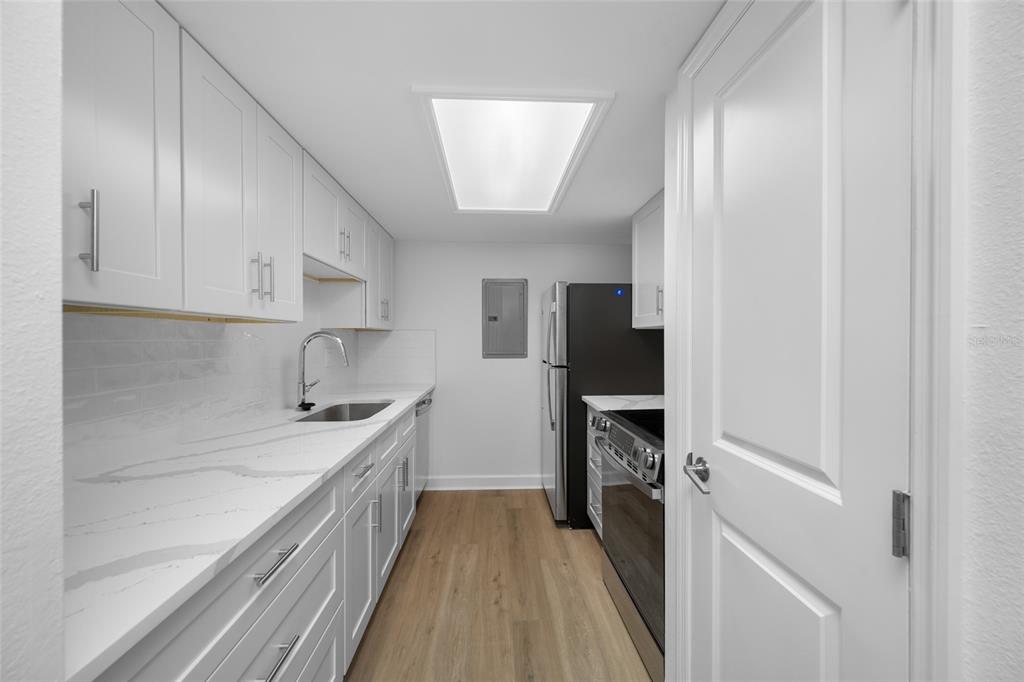 8911 Blind Pass Road, Unit 114 St. Pete Beach, FL 33706 - Photo 22 of 43 a kitchen with a sink and refrigerator