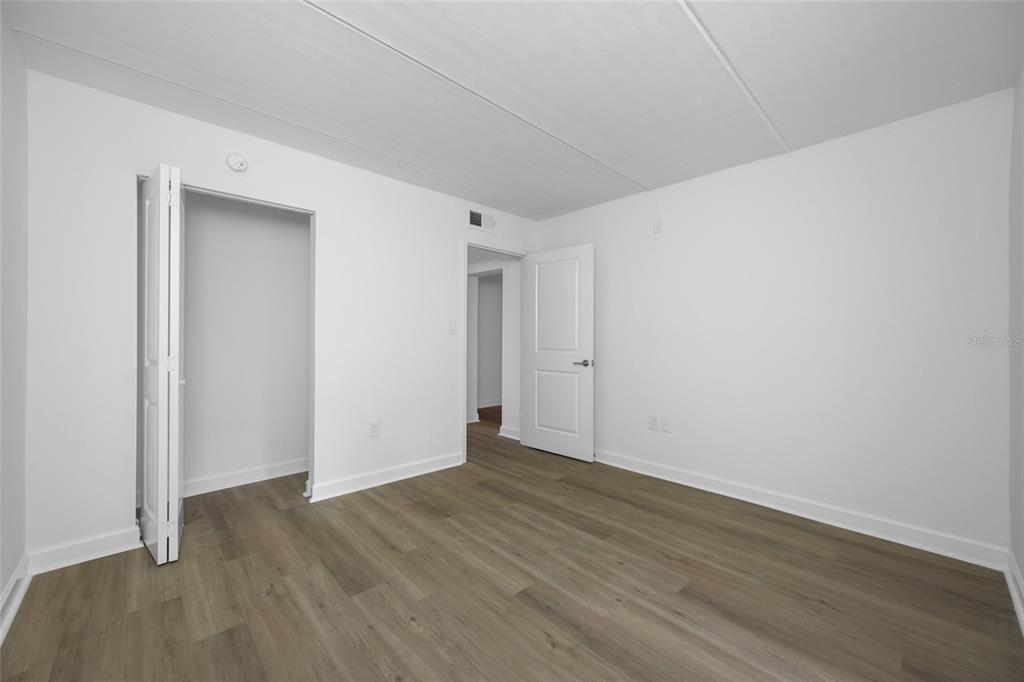 8911 Blind Pass Road, Unit 114 St. Pete Beach, FL 33706 - Photo 25 of 43 a view of an empty room with wooden floor