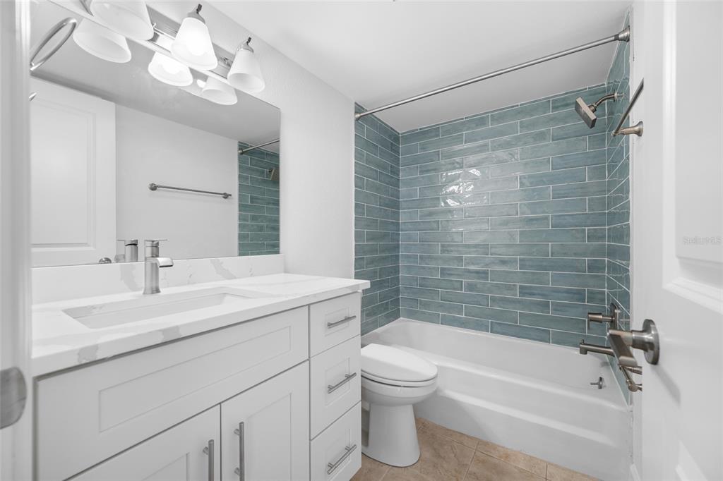 8911 Blind Pass Road, Unit 114 St. Pete Beach, FL 33706 - Photo 26 of 43 a bathroom with a sink a toilet and shower