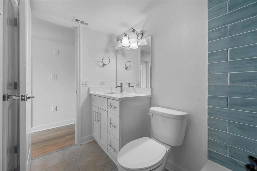 8911 Blind Pass Road, Unit 114 St. Pete Beach, FL 33706 - Photo 27 of 43 a bathroom with a toilet sink and mirror