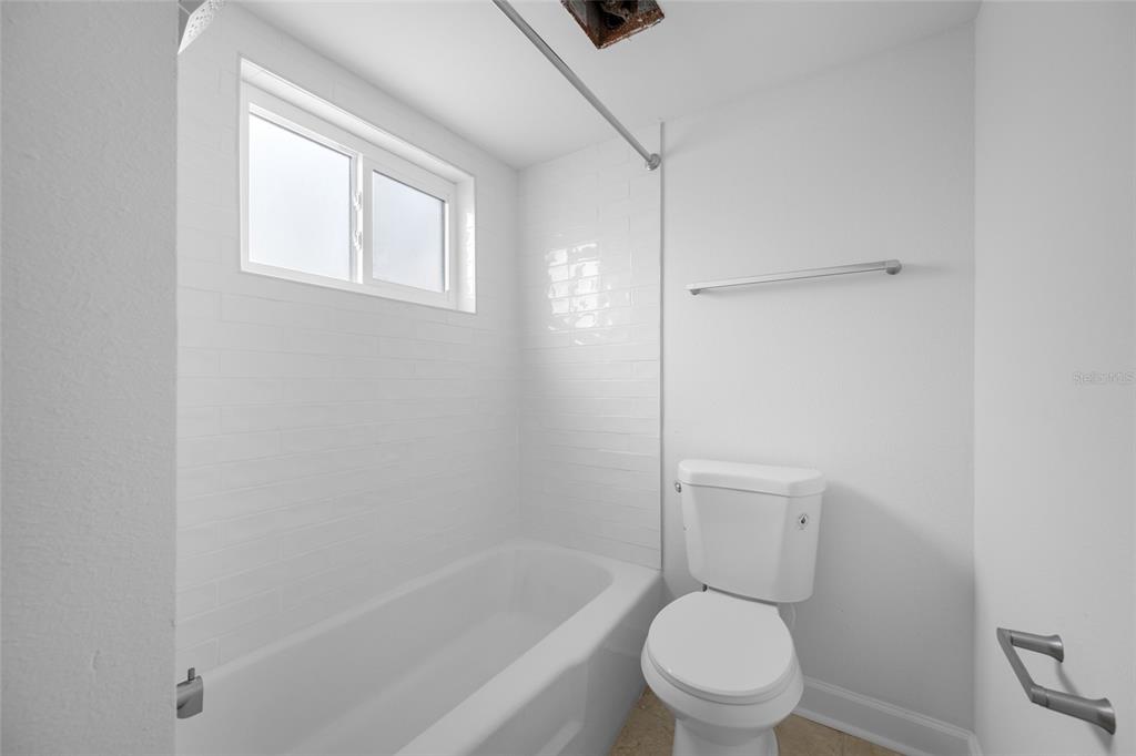 8911 Blind Pass Road, Unit 114 St. Pete Beach, FL 33706 - Photo 29 of 43 a white toilet sitting next to a bath tub