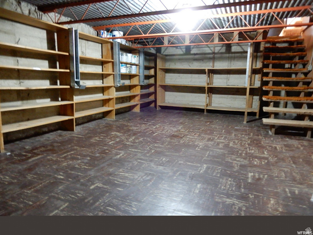490 Averett Avenue Springville, UT 84663 - Photo 2 of 14 Spacious storage area featuring extensive built-in wooden shelving, exposed ceiling joists, and a partial wooden staircase