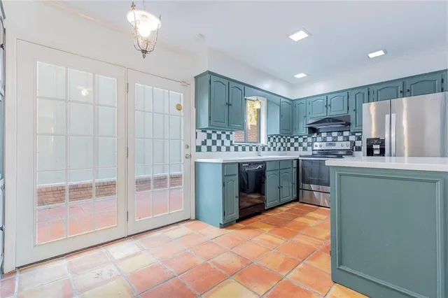 a kitchen with stainless steel appliances kitchen island granite countertop a refrigerator and a sink