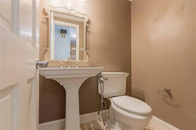 a bathroom with a toilet sink and mirror