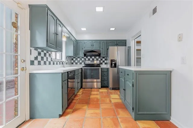 a kitchen with stainless steel appliances granite countertop a stove and a refrigerator