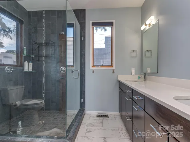 a bathroom with a double vanity sink toilet and shower