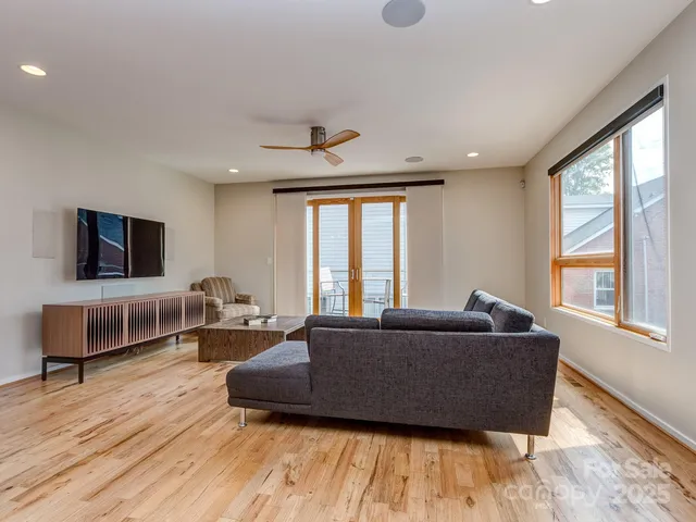 a living room with furniture flat screen tv and a large window