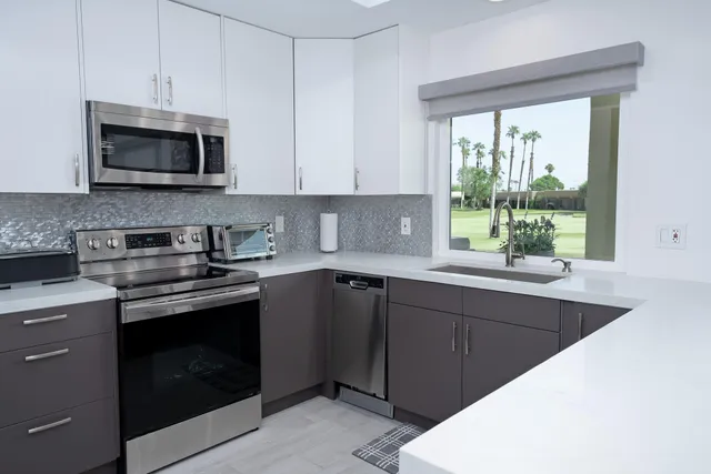 a kitchen with stainless steel appliances a stove sink and microwave