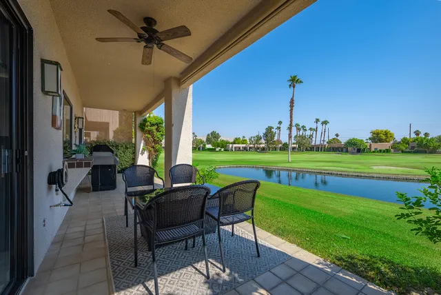 a view of a chairs and table in patio with a yard