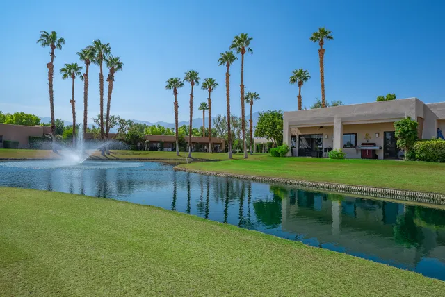 a view of a lake with a big yard and palm trees
