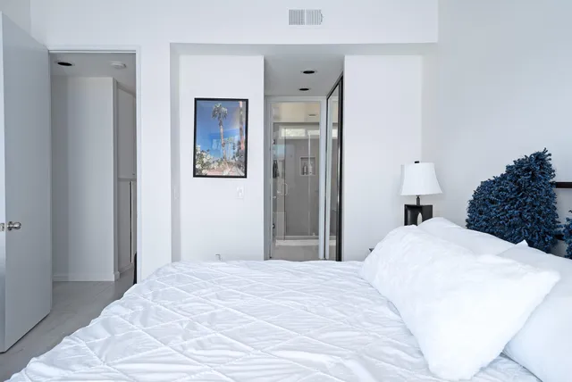 a bedroom with a large bed and a chandelier