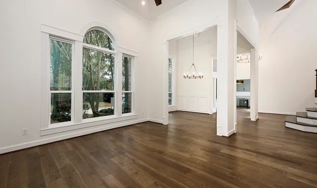 a view of an empty room with a kitchen and a window