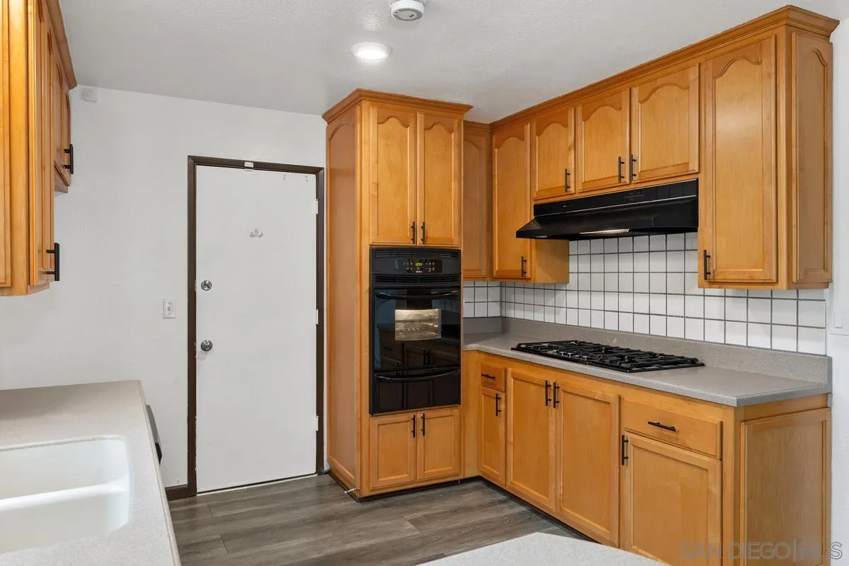 348 Sychar Road San Diego, CA 92114 - Photo 11 of 30 a kitchen with granite countertop cabinets and refrigerator