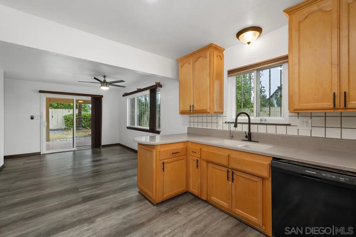 348 Sychar Road San Diego, CA 92114 - Photo 12 of 30 a kitchen with stainless steel appliances granite countertop a sink a stove cabinets and wooden floor