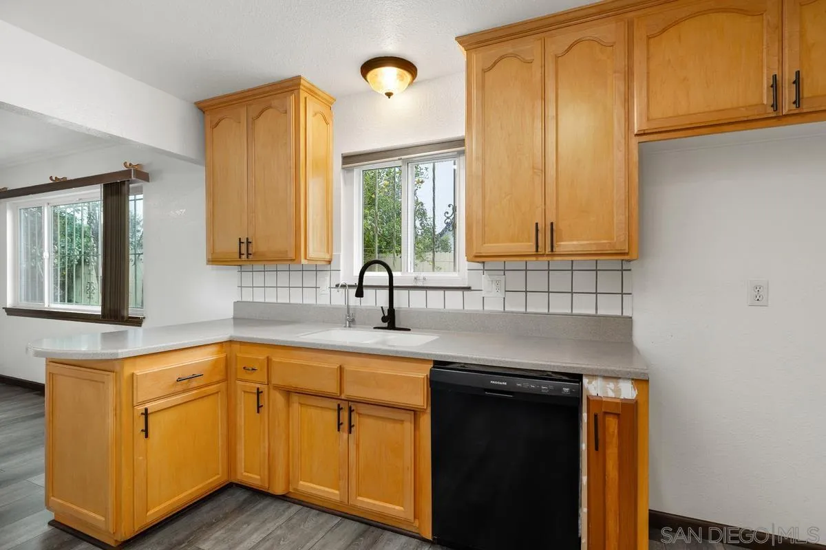 348 Sychar Road San Diego, CA 92114 - Photo 13 of 30 a kitchen with stainless steel appliances granite countertop a sink and cabinets with wooden floor