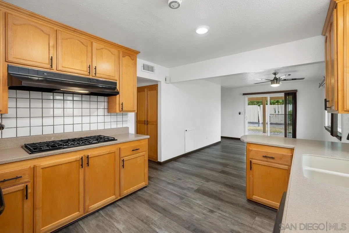 348 Sychar Road San Diego, CA 92114 - Photo 14 of 30 a kitchen with wooden cabinets and a stove top oven