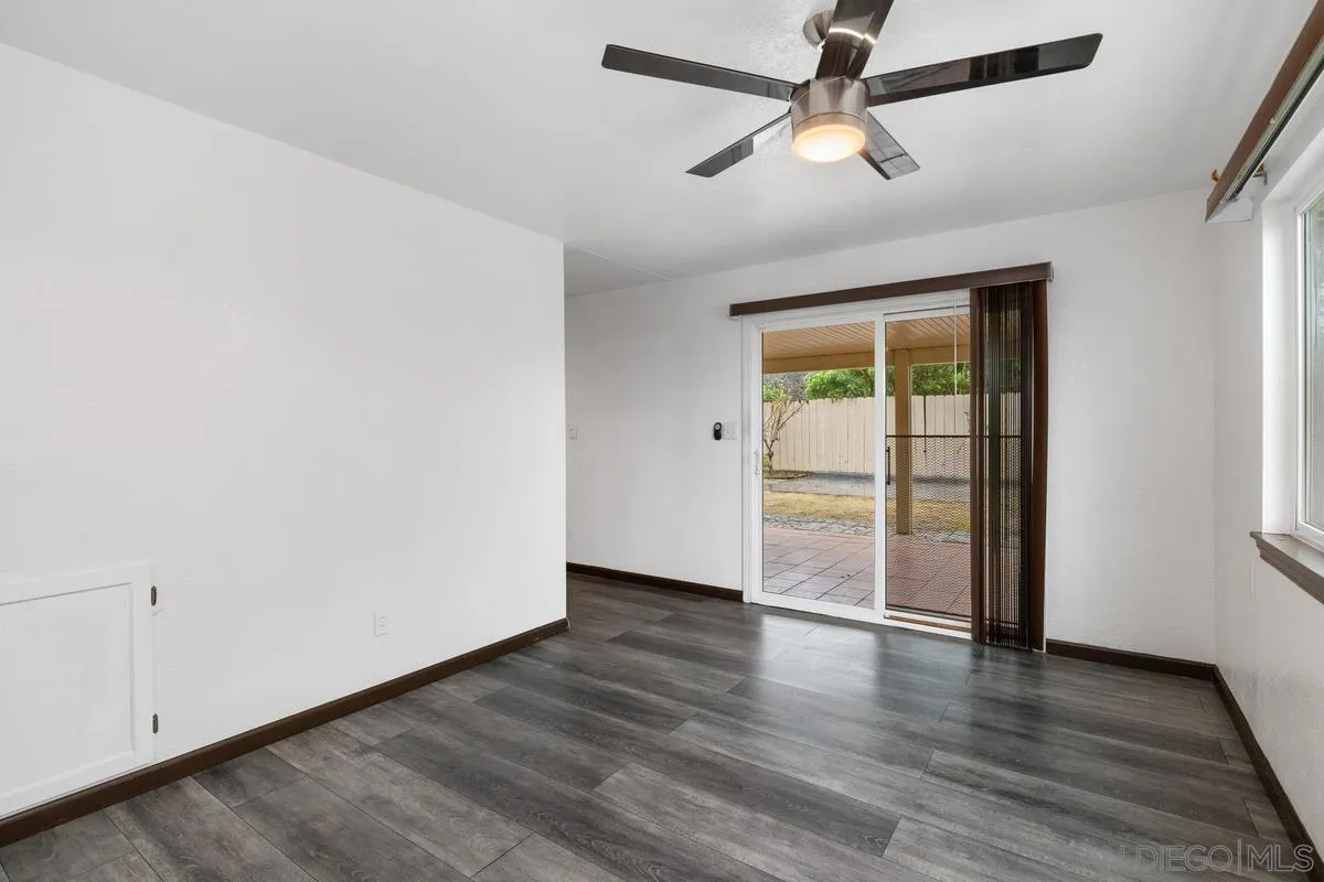 348 Sychar Road San Diego, CA 92114 - Photo 9 of 30 an empty room with wooden floor chandelier fan and windows