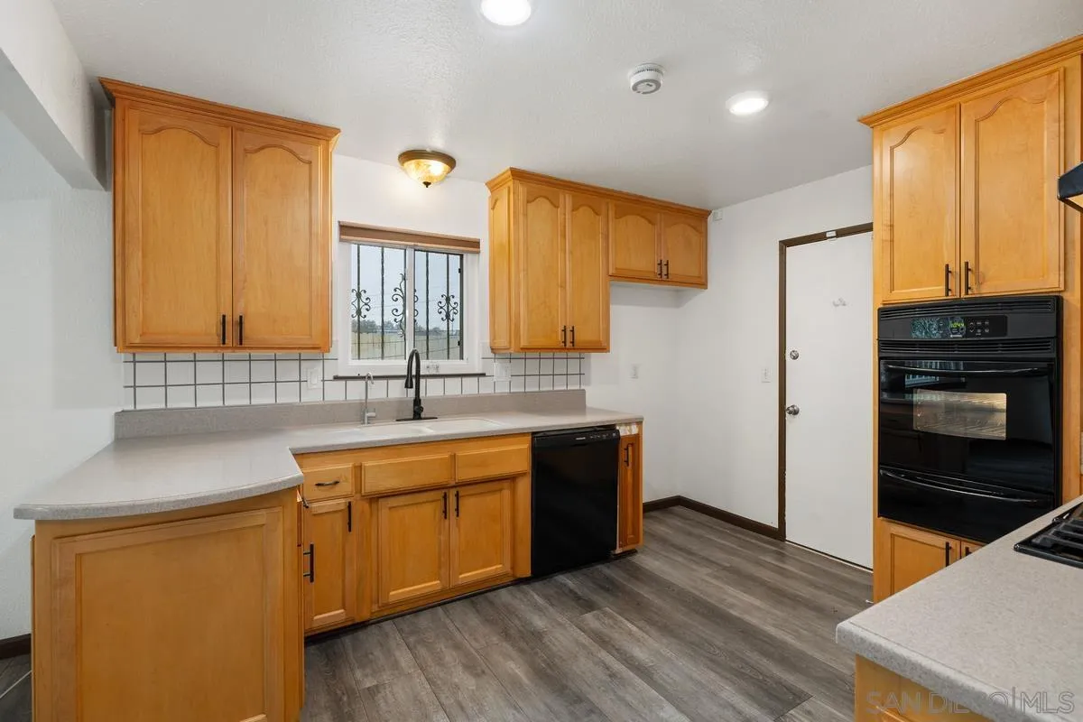 348 Sychar Road San Diego, CA 92114 - Photo 10 of 30 a kitchen with stainless steel appliances granite countertop a sink stove and refrigerator