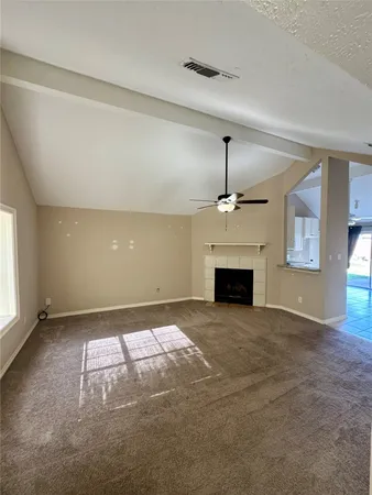 an empty room with windows and fireplace