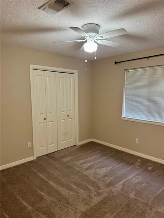 a view of an empty room with a chandelier fan