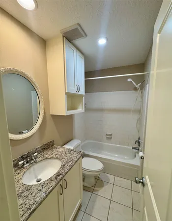 a bathroom with a granite countertop sink toilet and a mirror
