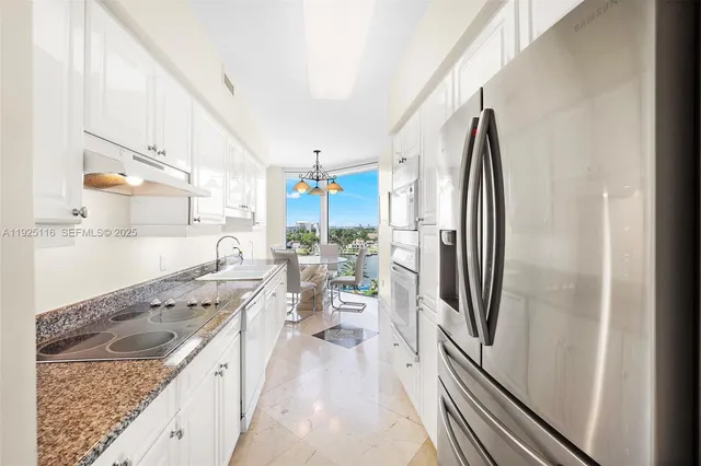 a kitchen with stainless steel appliances granite countertop a refrigerator a stove and a sink