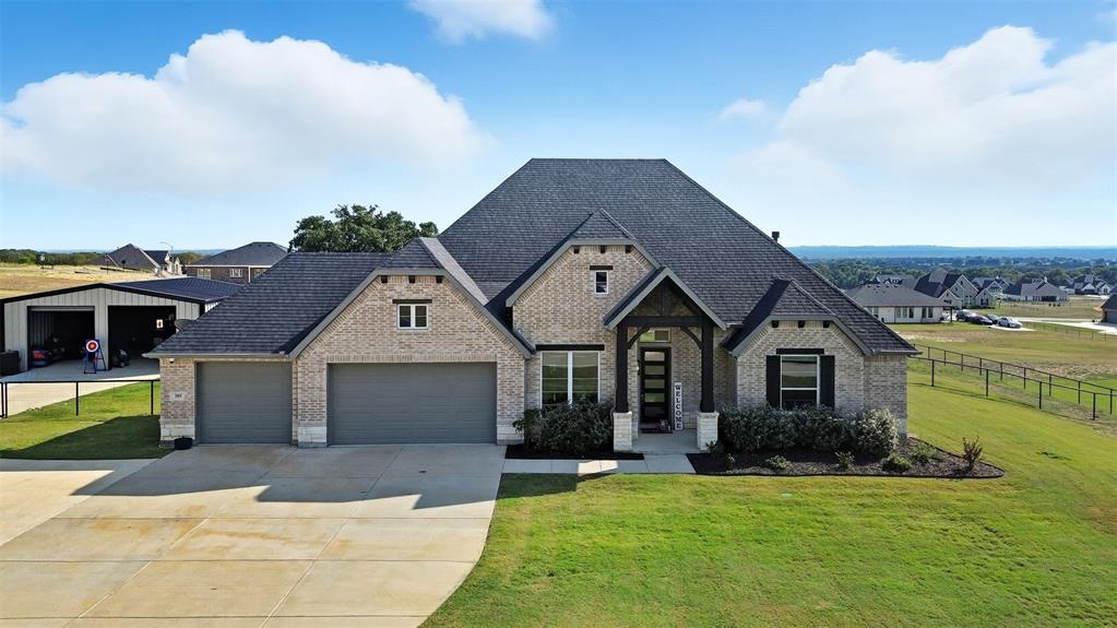 a front view of a house with a garden and yard