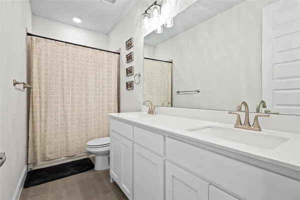 a bathroom with a double vanity sink toilet and shower