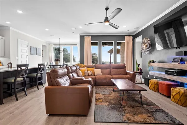 a living room with furniture kitchen view and a large window