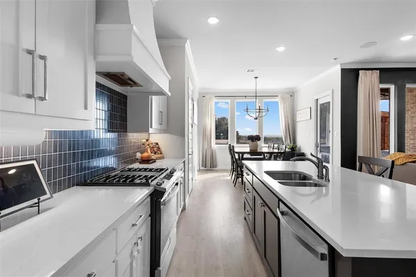 a kitchen that has a sink a stove and cabinets