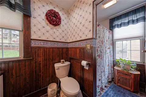a bathroom with a toilet a sink and a shower curtain