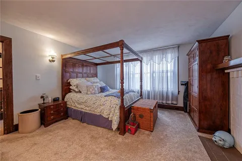 a bedroom with a large bed couch and a fireplace