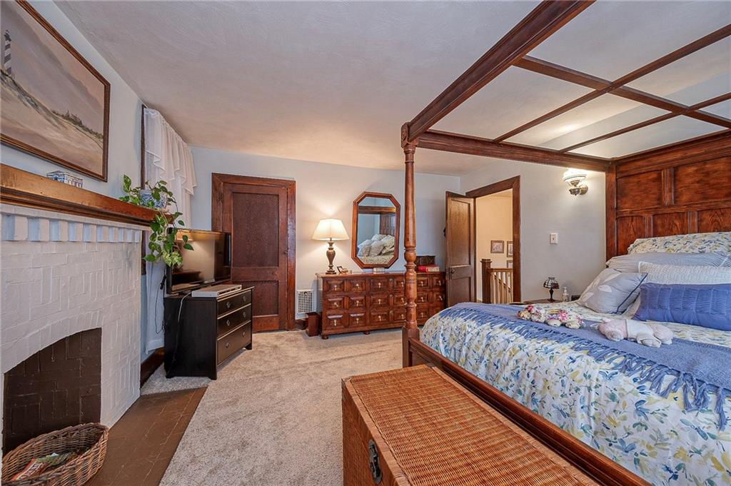 451 Walnut Street Pittsburgh, PA 15238 - Photo 23 of 40 a bedroom with a large bed couch and a fireplace