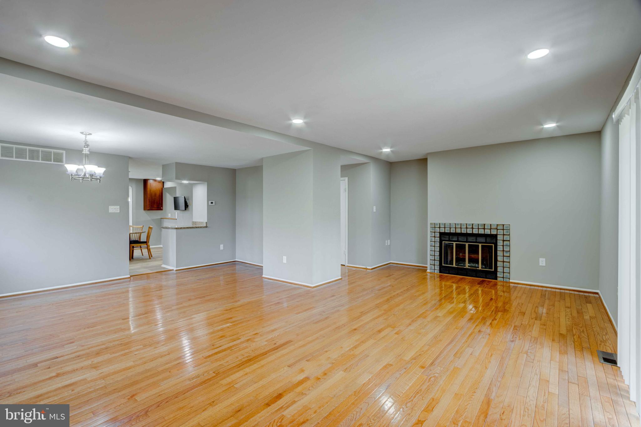 11859 Blue February Way Columbia, MD 21044 - Photo 4 of 35 a view of a livingroom with wooden floor and kitchen space