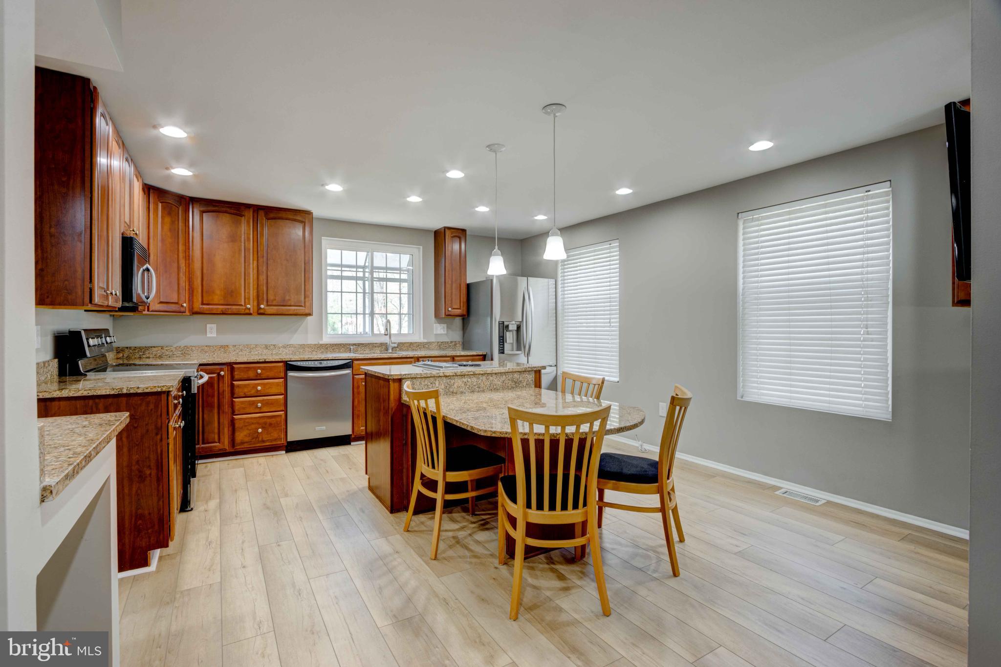 11859 Blue February Way Columbia, MD 21044 - Photo 10 of 35 a kitchen with a table chairs sink microwave and cabinets