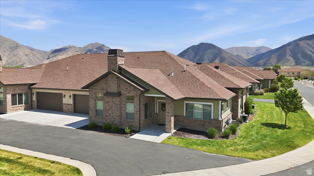 1838 West 300th Street South, Unit B Mapleton, UT 84664 - Photo 39 of 51 Brick and siding exterior featuring a multi-car driveway, attached garage, and a peaked roof