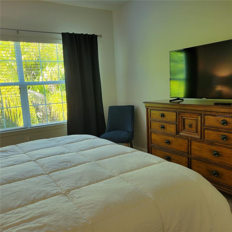 152 Navigation Circle, Unit 107 Osprey, FL 34229 - Photo 11 of 25 a bedroom with a bed and a flat screen tv