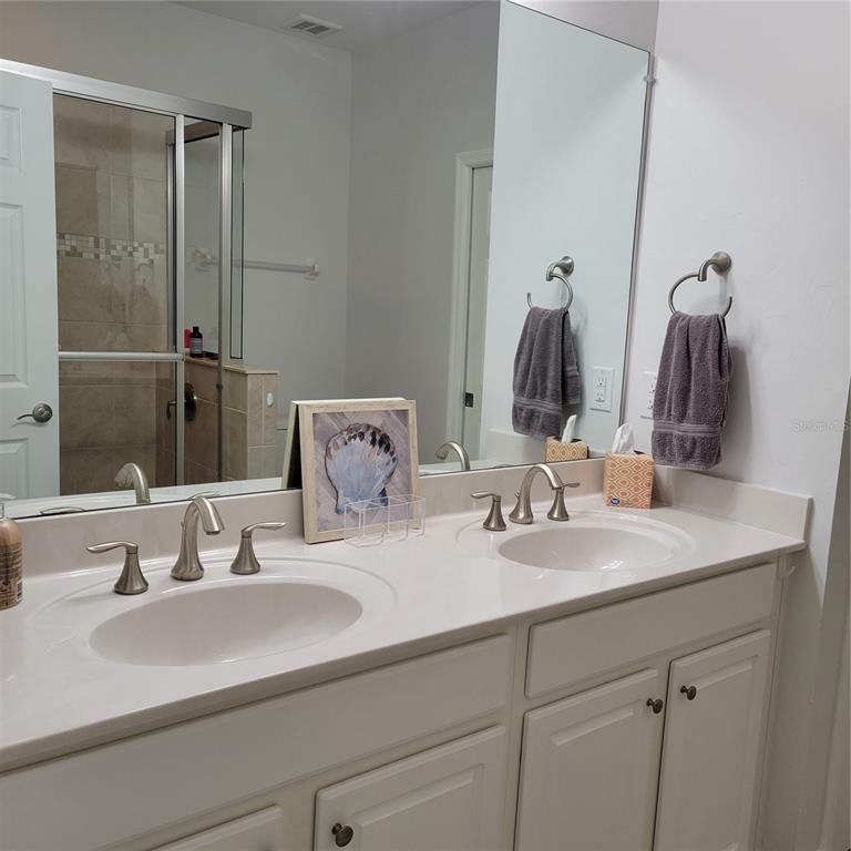 152 Navigation Circle, Unit 107 Osprey, FL 34229 - Photo 12 of 25 a bathroom with double vanity sinks and a mirror
