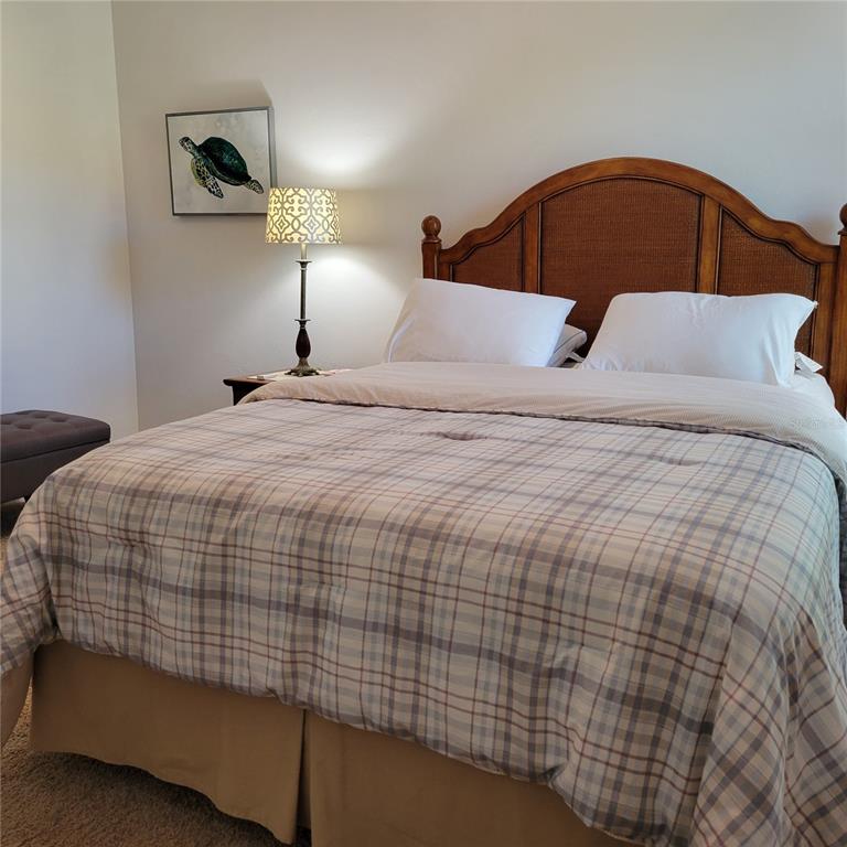 152 Navigation Circle, Unit 107 Osprey, FL 34229 - Photo 14 of 25 a bedroom with a bed and a night stand