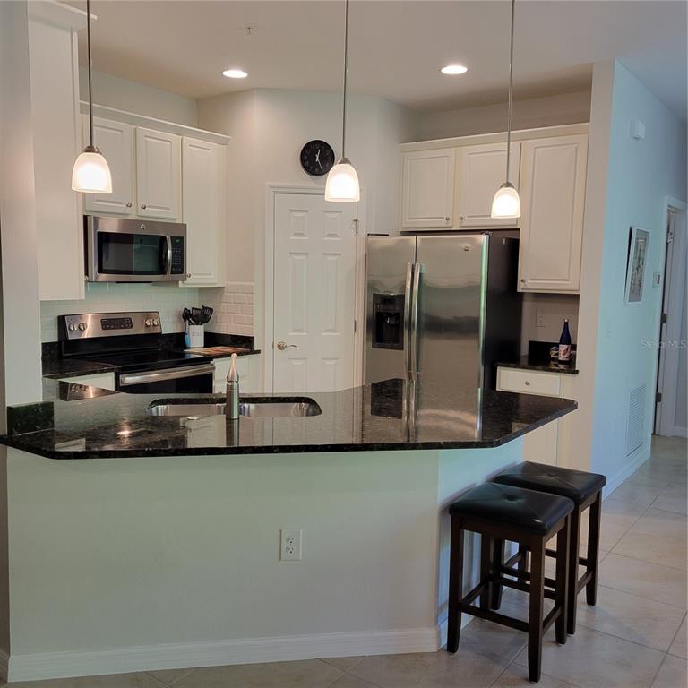152 Navigation Circle, Unit 107 Osprey, FL 34229 - Photo 4 of 25 a kitchen with stainless steel appliances a microwave a stove and a refrigerator