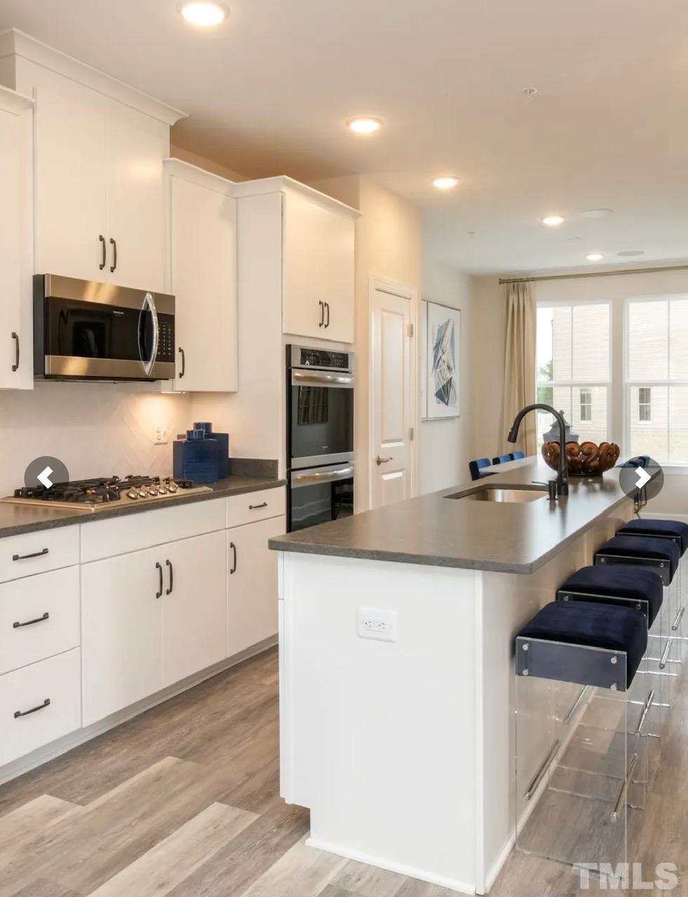a kitchen with stainless steel appliances granite countertop a sink a stove and microwave