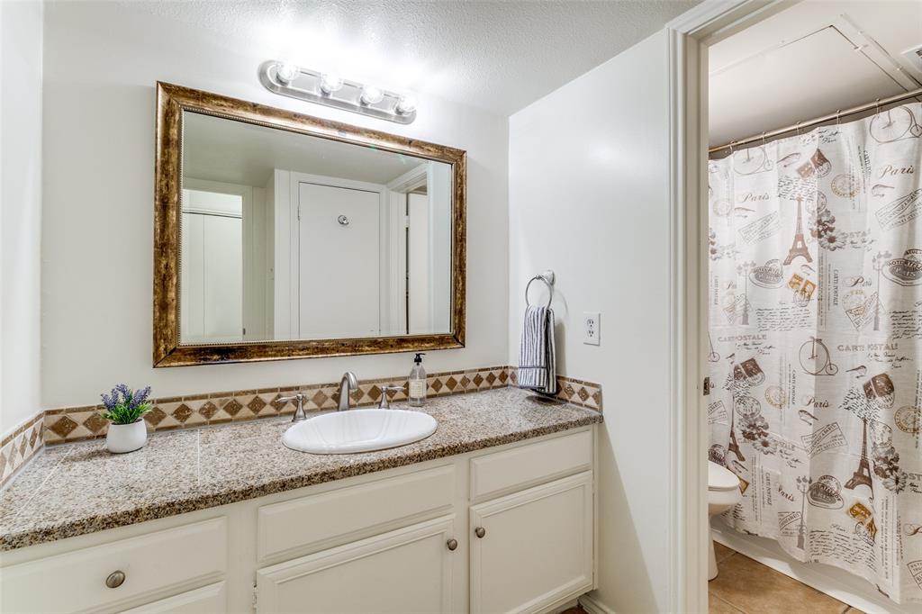 15151 Berry Trail, Unit 407 Dallas, TX 75248 - Photo 12 of 16 a bathroom with a granite countertop sink and a mirror