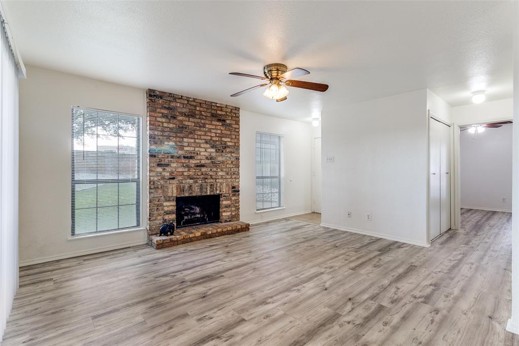 15151 Berry Trail, Unit 407 Dallas, TX 75248 - Photo 4 of 16 a view of a livingroom with wooden floor a fireplace and window