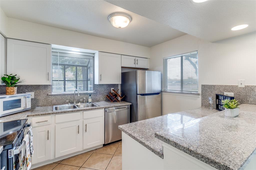15151 Berry Trail, Unit 407 Dallas, TX 75248 - Photo 9 of 16 a kitchen with stainless steel appliances granite countertop a sink stove and refrigerator